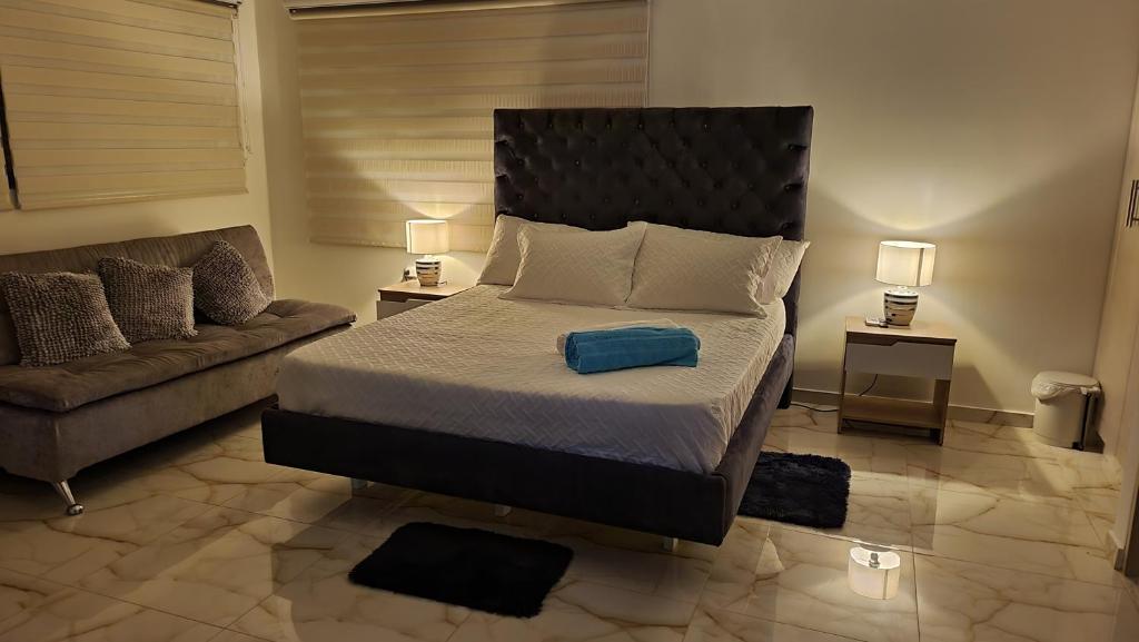 吉拉尔多特PISCINA SARITA CLUB BOUTIQUE的一间卧室配有一张大床和一张沙发
