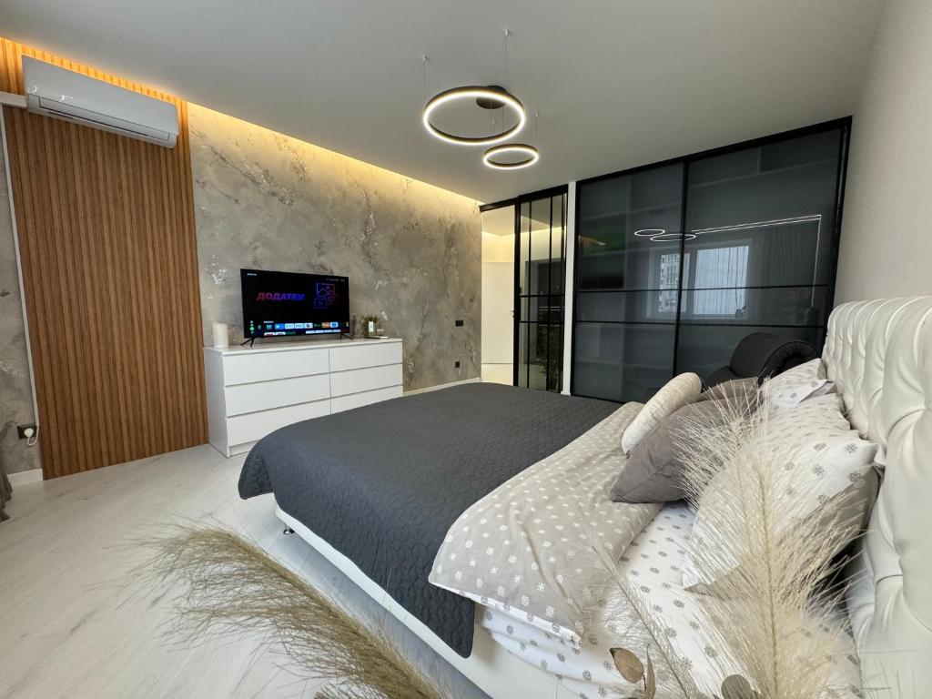 文尼察Квартира на Подолье的卧室配有一张大床,墙上配有电视