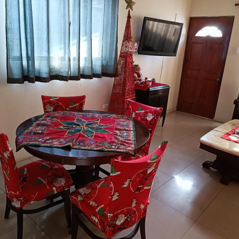 伊基克Casa dos dormitorios的一间带桌子和红色椅子的用餐室