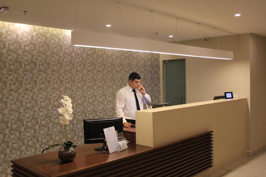 里约热内卢加利西亚酒店的办公室里的一个男人在手机上讲话