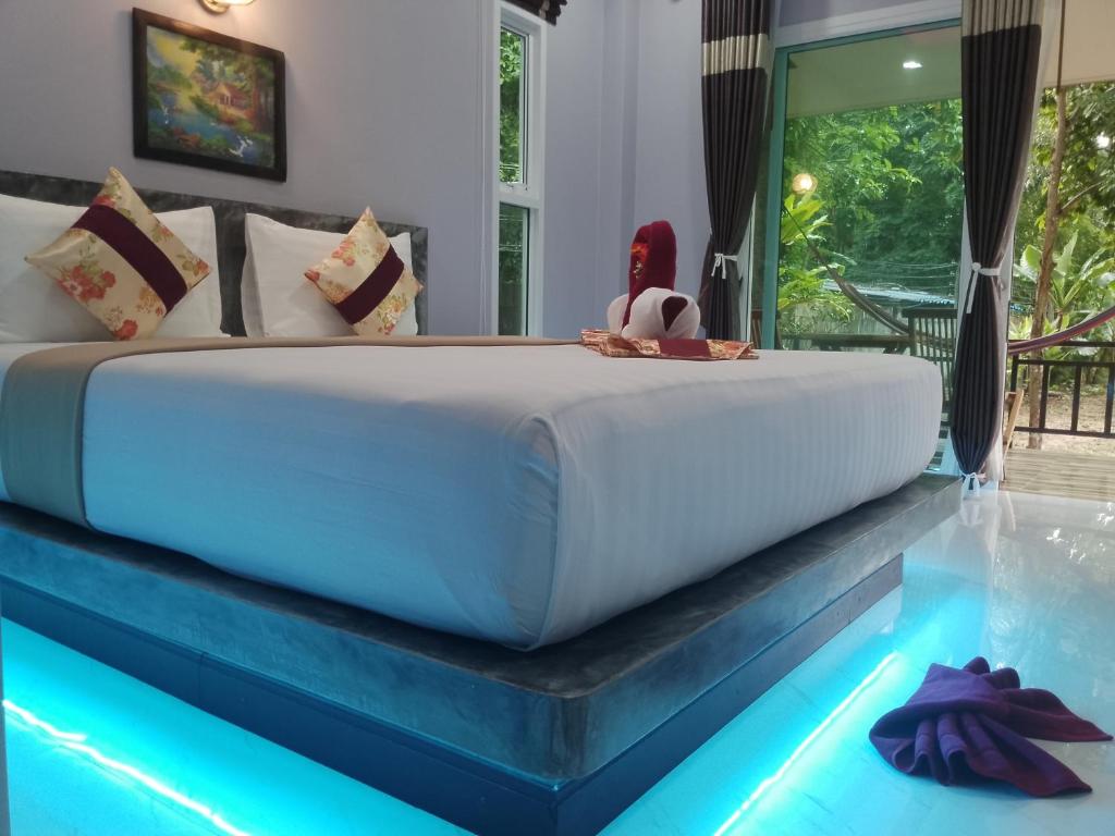 高兰Pana Long Beach Resort - SHA Plus的一间带大床的卧室和一个游泳池