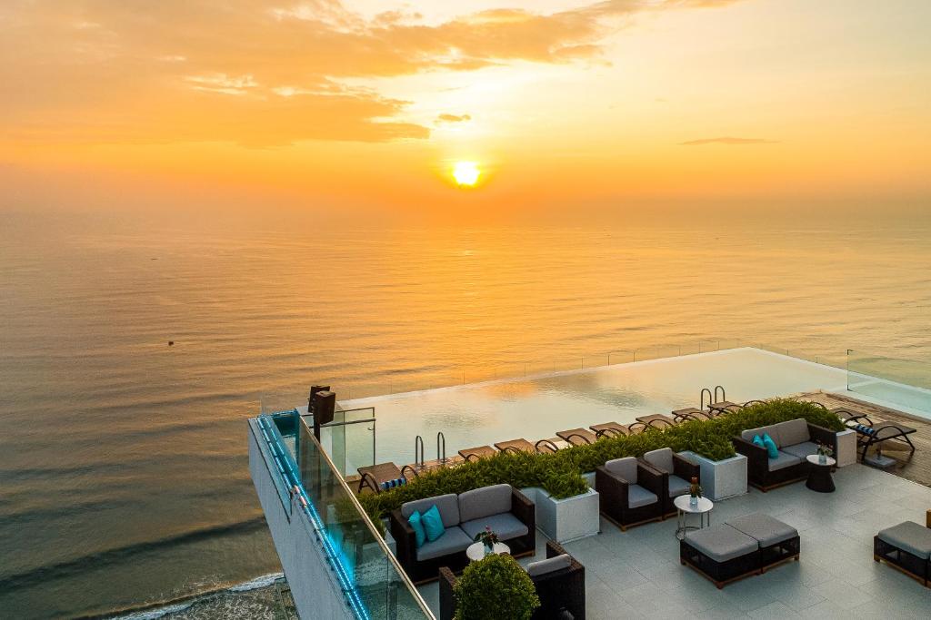 岘港TMS Hotel Da Nang Beach的日落时分从度假酒店欣赏到海景