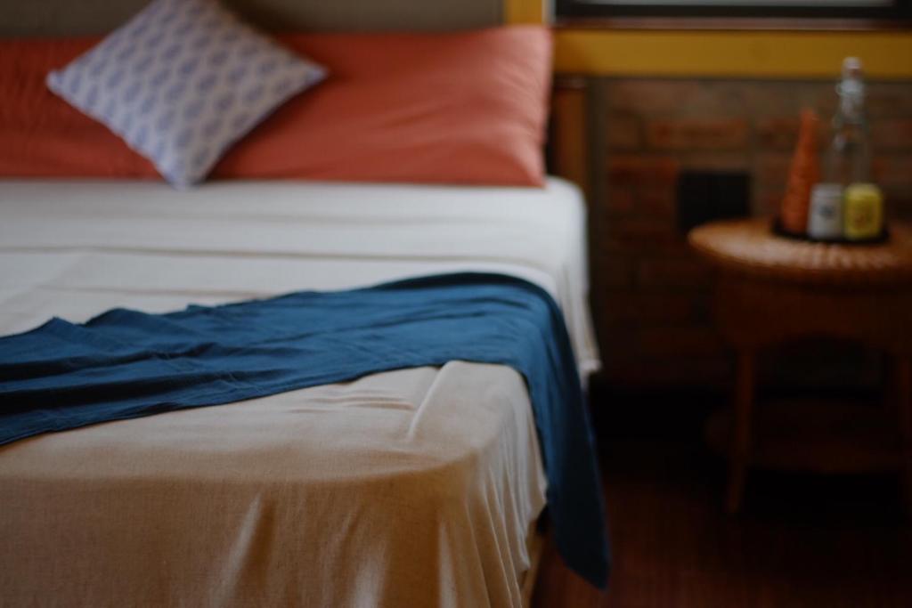 顺化Lagom Home的一张床上的密闭床,上面有蓝色的毯子