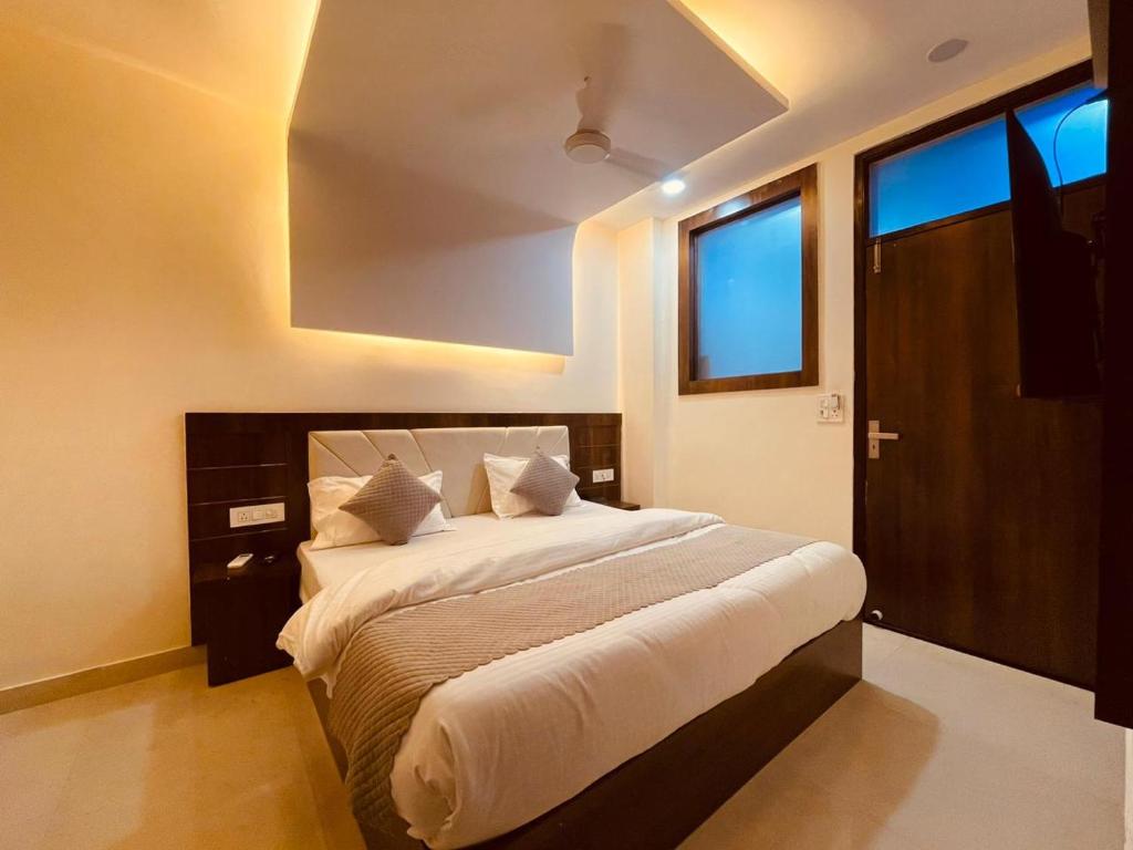 哈里瓦The White House Haridwar的一间卧室配有一张带白色床单的大床