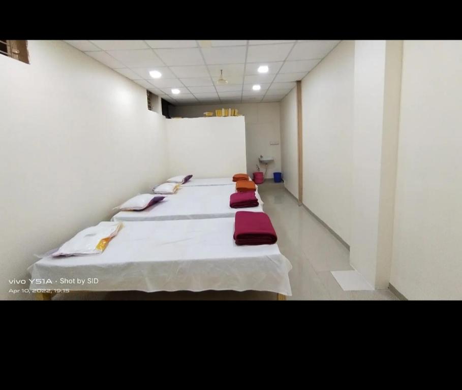 潘达尔普尔Shree Radhesh Bhakt Niwas的一间设有一排红色枕头的床的房间