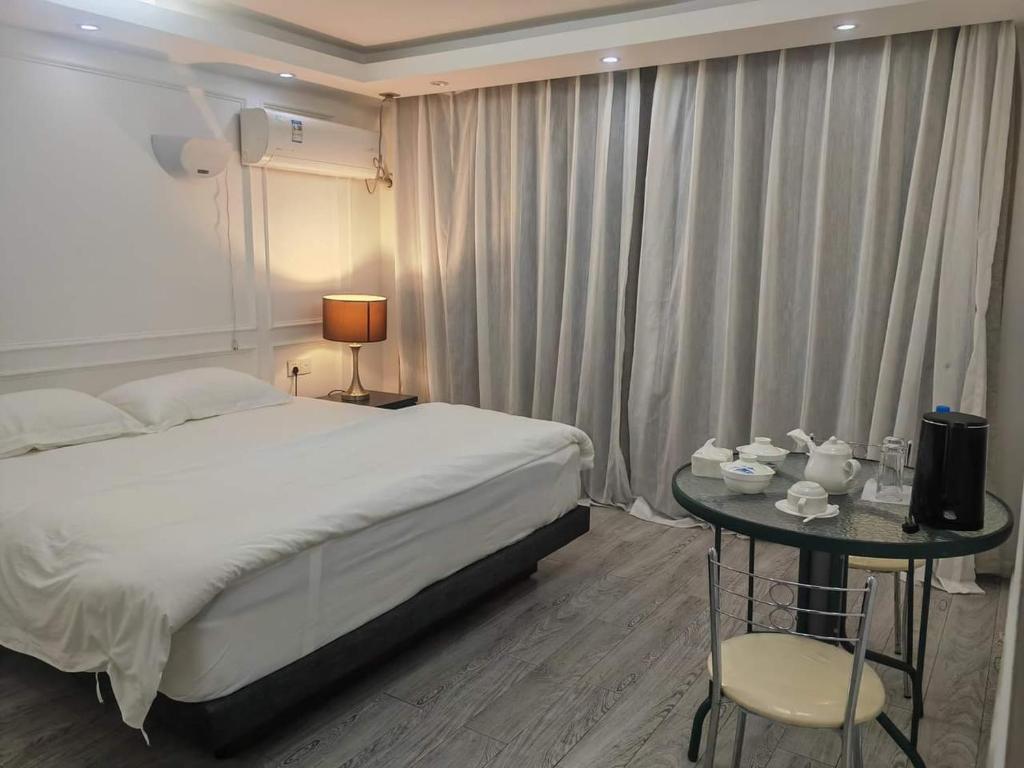 HofoaLATA HOTEL的一间卧室配有一张床和一张桌子及椅子