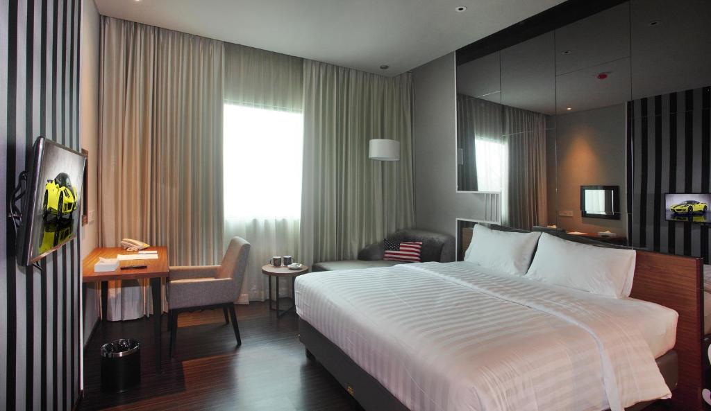 雅加达卡宾酒店的酒店客房设有一张大床和一张书桌。