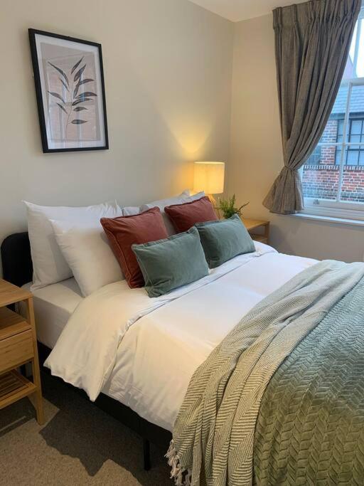伯明翰The Jade Suite - The Jewellery Suites, 3 bed 3 bath的卧室配有带枕头的床铺和窗户。