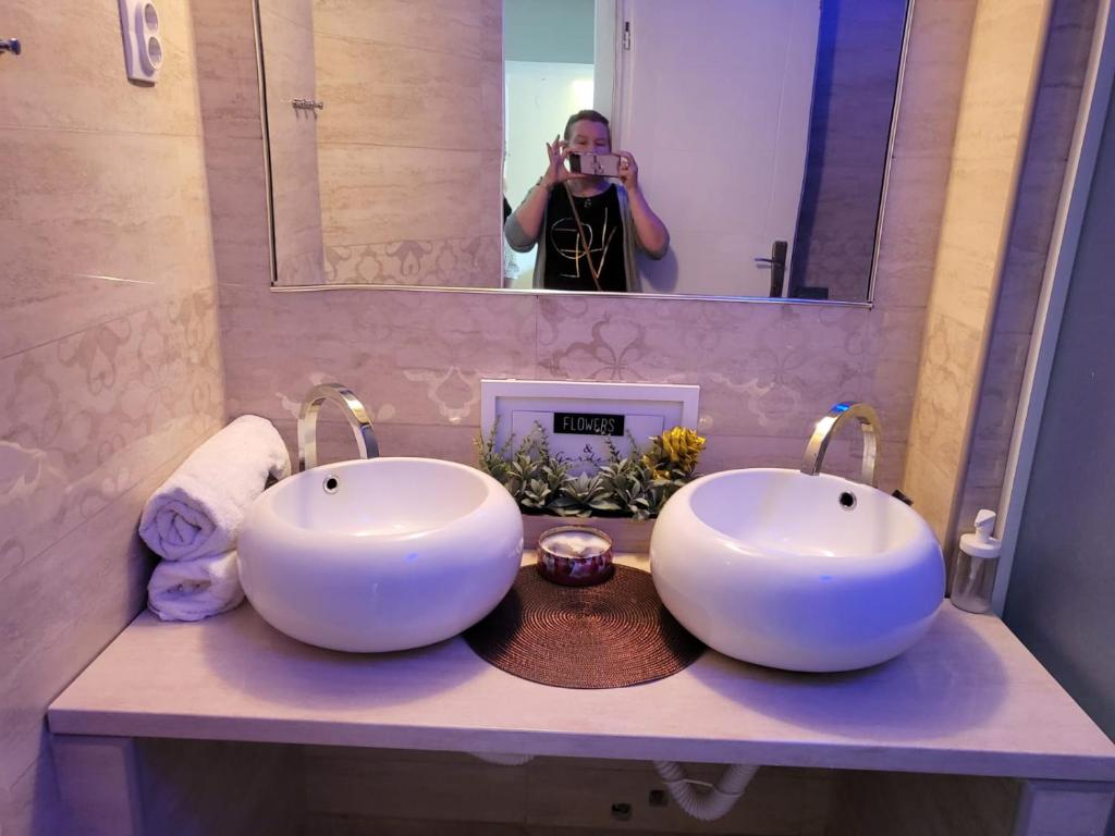 里巴斯卡班亚Vila Marija的一位女性在浴室里拍着两个水槽的照片