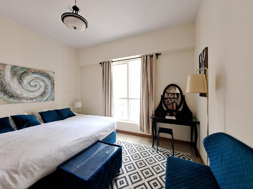 迪拜Serenity Paradise 2BR in Marina的一间卧室配有一张床、一张书桌和一个窗户。