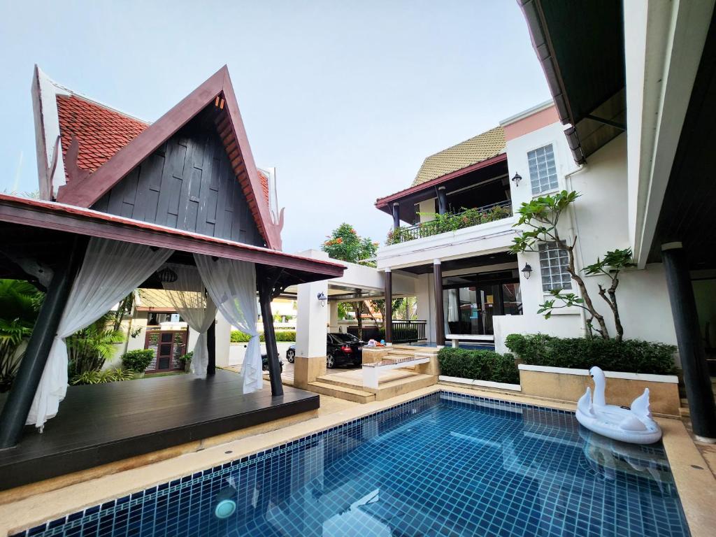 乔木提恩海滩รมิดา พูล วิลล่า พัทยา Ramida Pool Villa Pattaya的房屋前有游泳池的房子