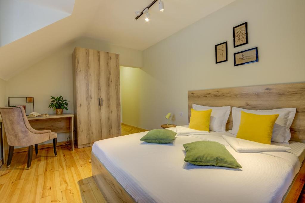 比什凯克People Guest House的一间卧室配有一张大床,提供黄色和绿色的枕头