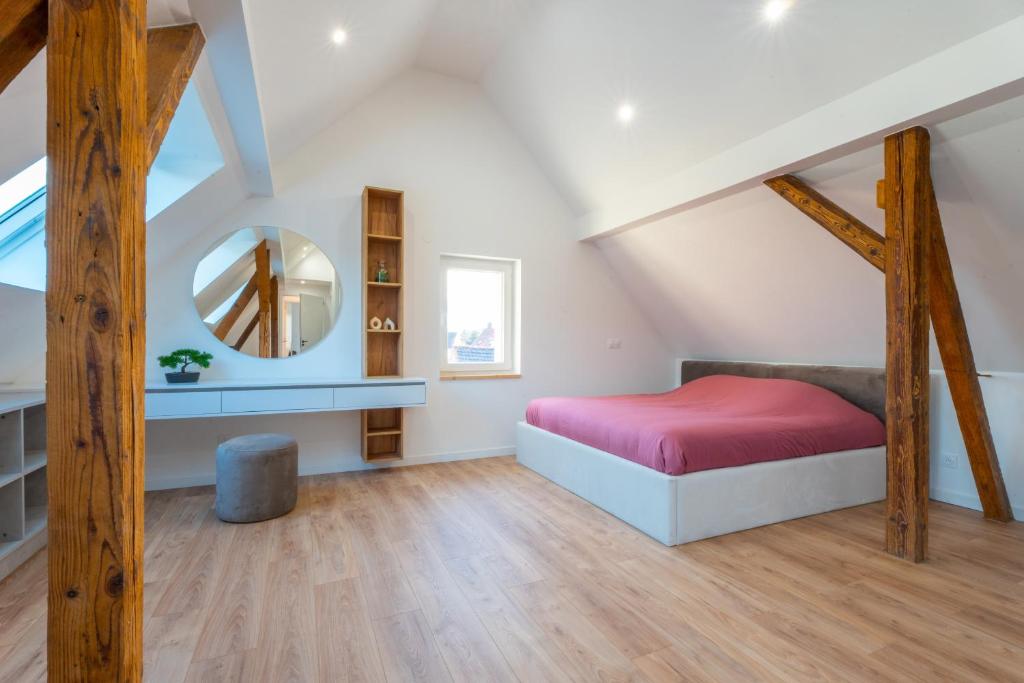利戈尔塞姆Magnifique maison neuve的阁楼卧室配有床和镜子