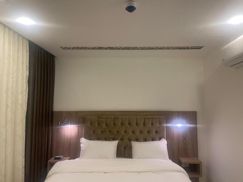 安曼Antalya Hotel Amman的卧室配有带白色枕头的大床