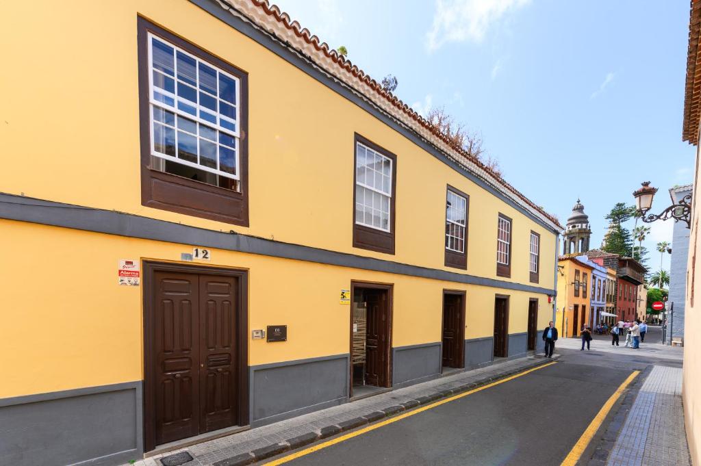 拉拉古纳Marhaba La Laguna, alojamiento en centro histórico de San Cristóbal de La Laguna的街上的黄色建筑,有棕色门