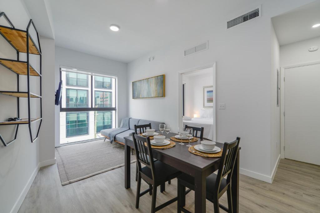 迈阿密Comfortable Apartment in Charming Wynwood的用餐室以及带桌椅的起居室。