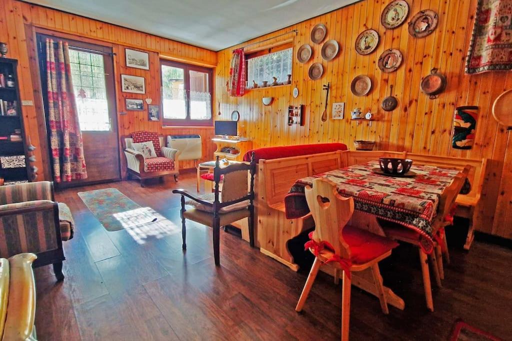 布吕松Fionisco - Giardino privato con vista sulle Alpi的一间带桌子和木墙的用餐室
