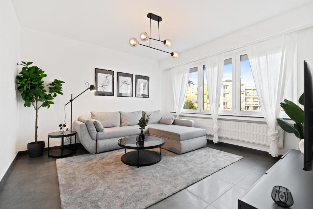 卢森堡Charming 1BR Apt w/ Terrace & 5 min Drive to City的白色的客厅配有沙发和桌子