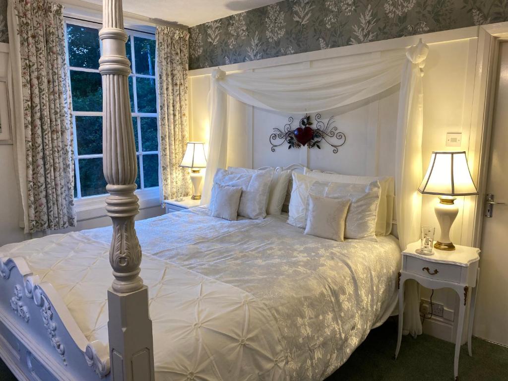 蒙哥马利Dolforwyn Hall的一间卧室配有一张带天蓬的白色床