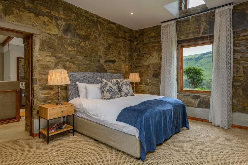 埃斯特科特Zulu Waters Game Reserve的一间卧室设有一张床和石墙