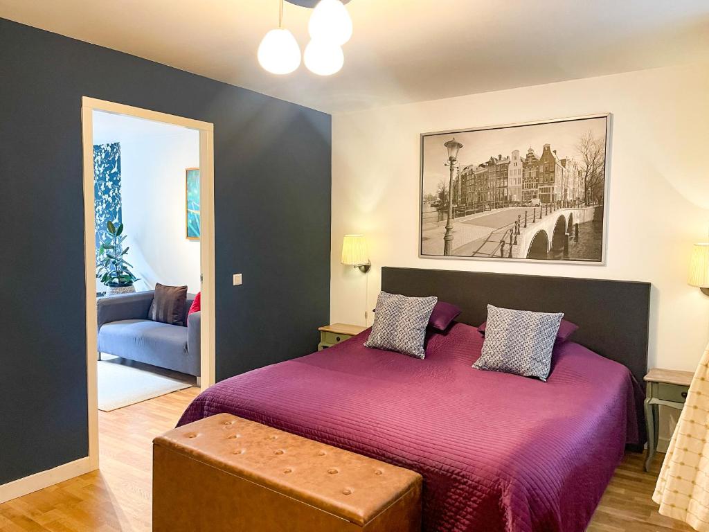 阿姆斯特丹阿姆斯特丹艺术家旅馆的一间卧室配有一张带紫色毯子的床