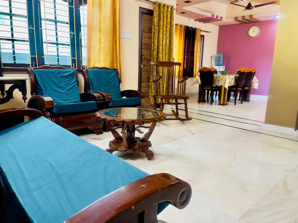 海得拉巴Prince Castle-4BHK Apartment,Guesthouse的客厅配有椅子和桌子。