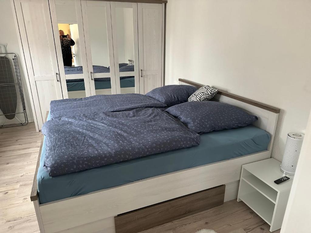 SulzbachFerienwohnung 2, 1. OG Nähe Augenklinik的卧室内的一张带蓝色床单和枕头的床