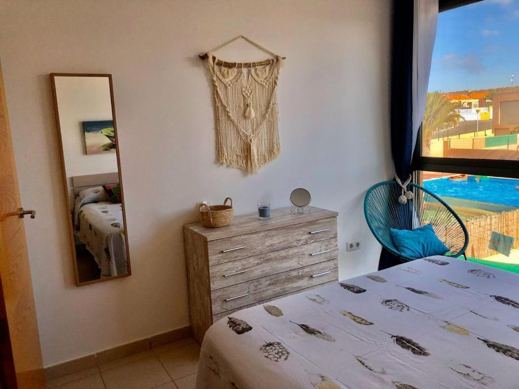 科斯塔德安提瓜Villa Costa Antigua Piscina的一间卧室配有一张床、镜子和窗户