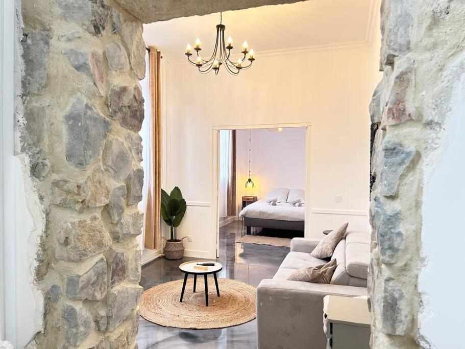 栋弗龙Élégant*Epoxy*Design&Décor的带沙发和石墙的客厅