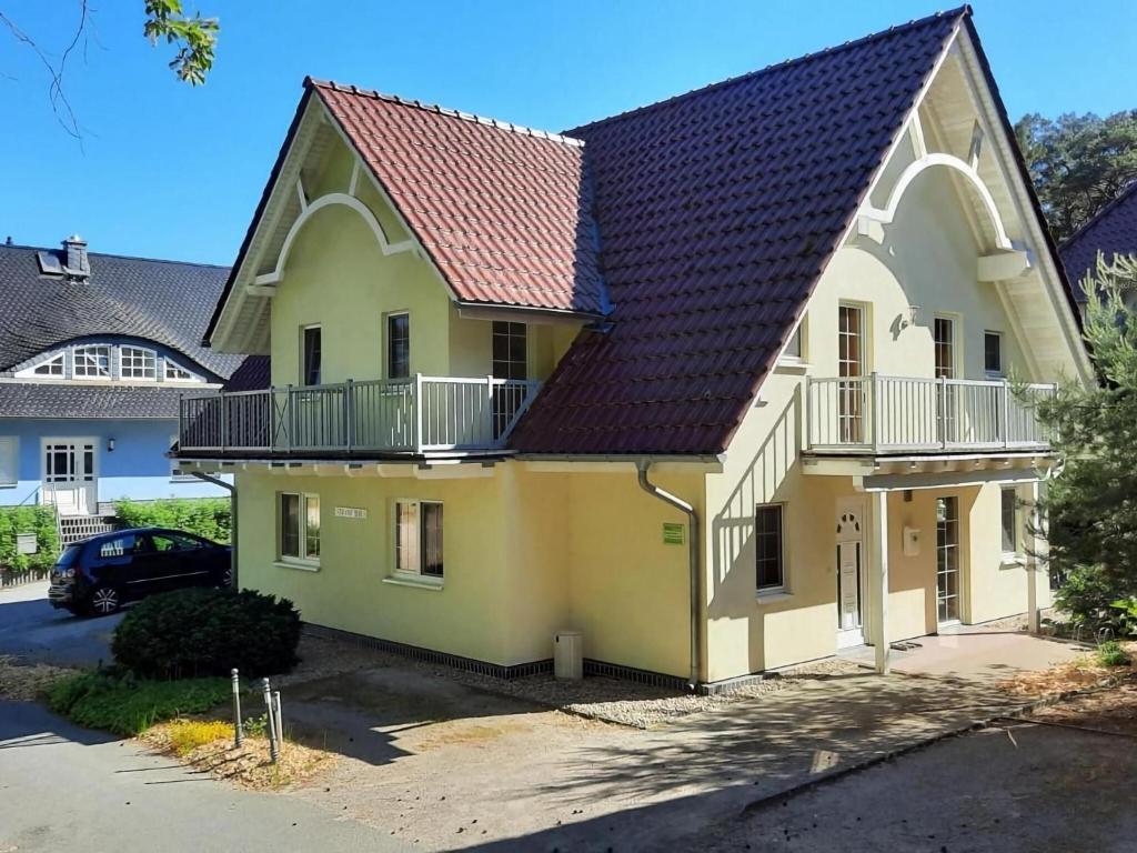 特拉森海德Semi-detached house Strandhaus II, Trassenheide的黄色的房屋,有红色的屋顶