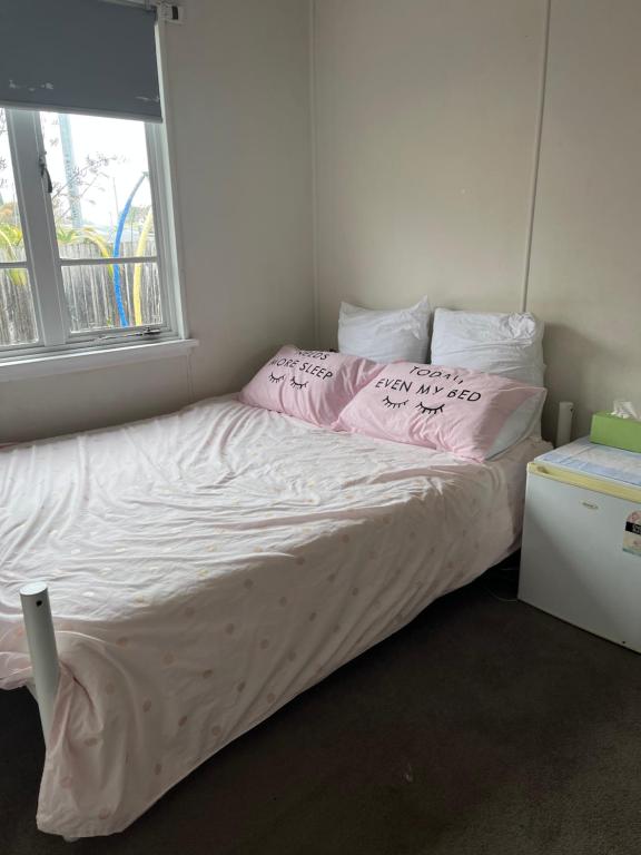 WarraneJennifer的一间卧室配有带粉红色枕头的床和窗户。