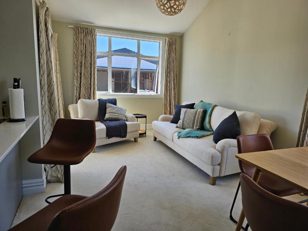 基督城Aspiring Villa Apartment的客厅配有两张沙发和一张桌子