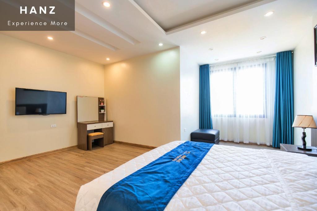 河内HANZ Noi Bai Airport Hotel的一间卧室配有一张大床和电视