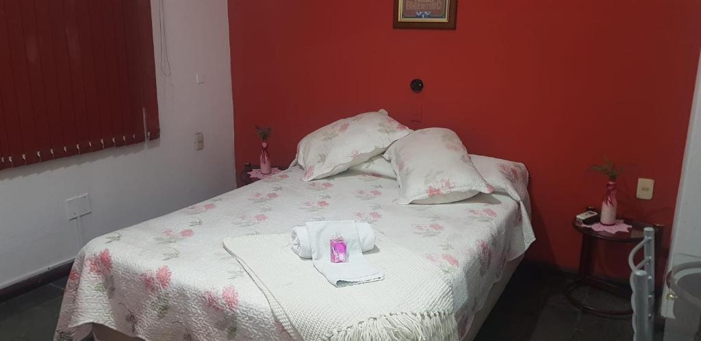 Bella UniónHotel Bella Unión的一张带两个枕头的床和一张粉红色的蜡烛