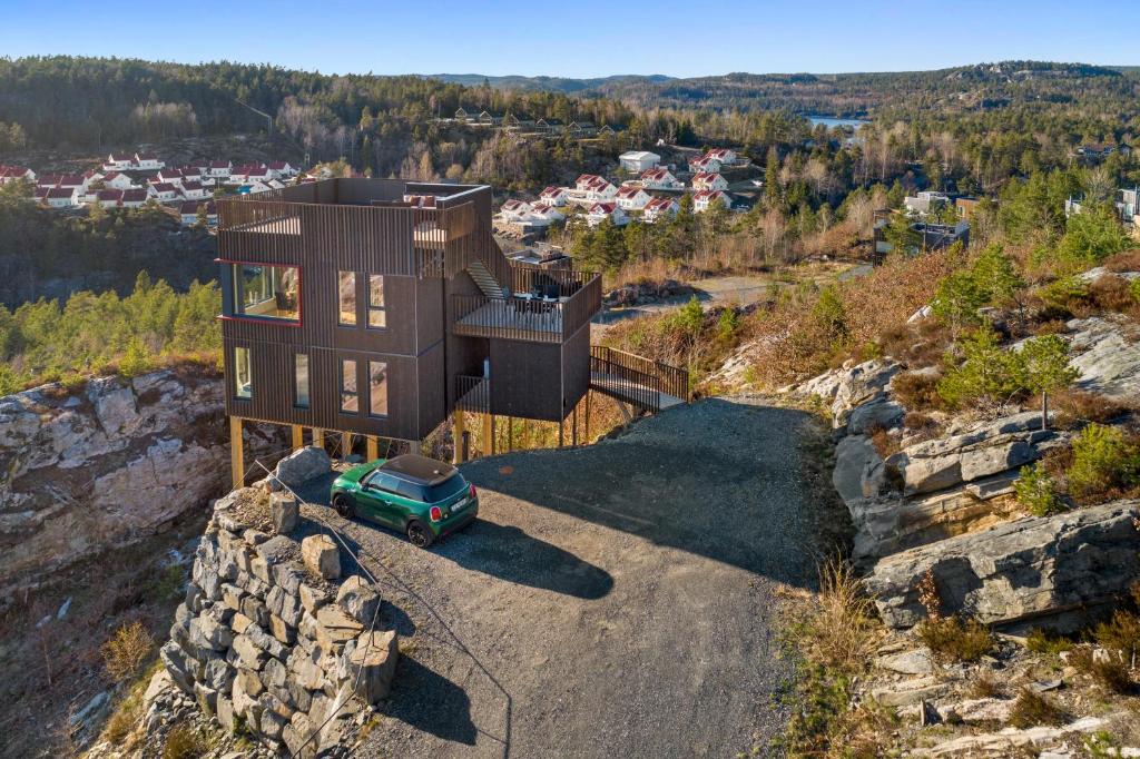 SøndeledCabin with sea and lake view的山顶上带绿色汽车的房子