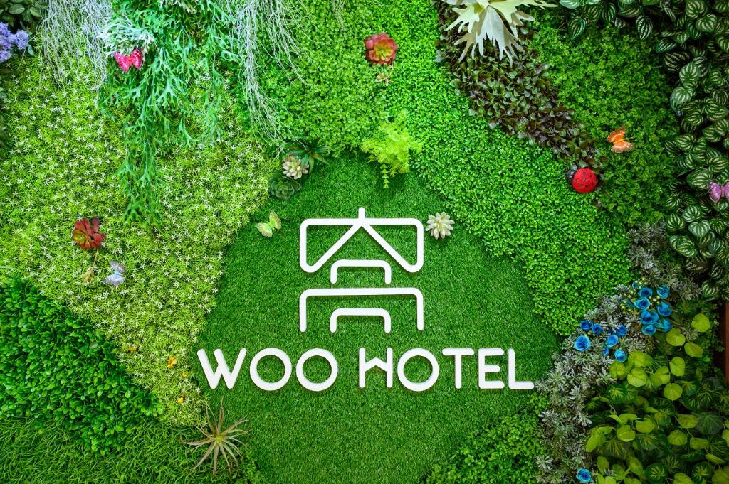 东京Ueno Woo Hotel的一个带阅读swoo汽车旅馆标志的花园