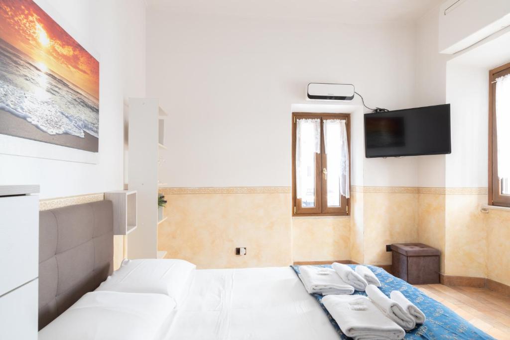 罗马Elegant & Quiet Apartment next to Colosseo的卧室配有白色的床和平面电视。