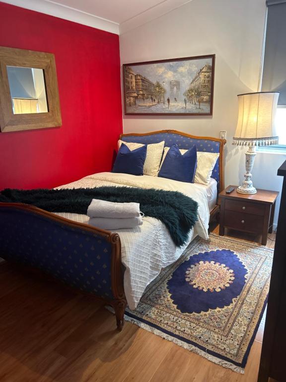 珀斯Whitfords Delight Homestay的一间卧室设有一张床和红色的墙壁