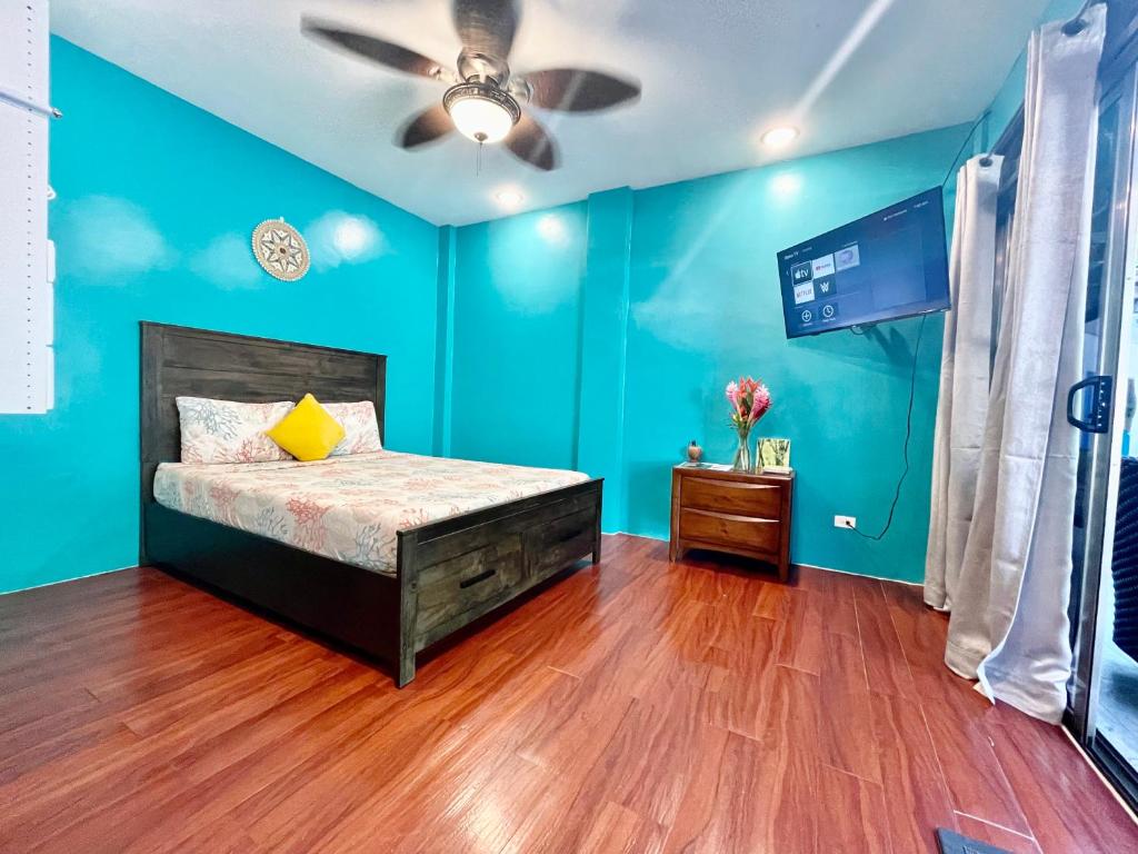 科罗尔Ngermid Oasis- 2 BD Master Suite的蓝色卧室配有床和吊扇