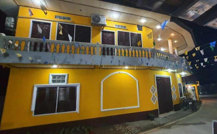 Muang KhôngMR Mo Guest House的黄色的建筑,上面设有阳台