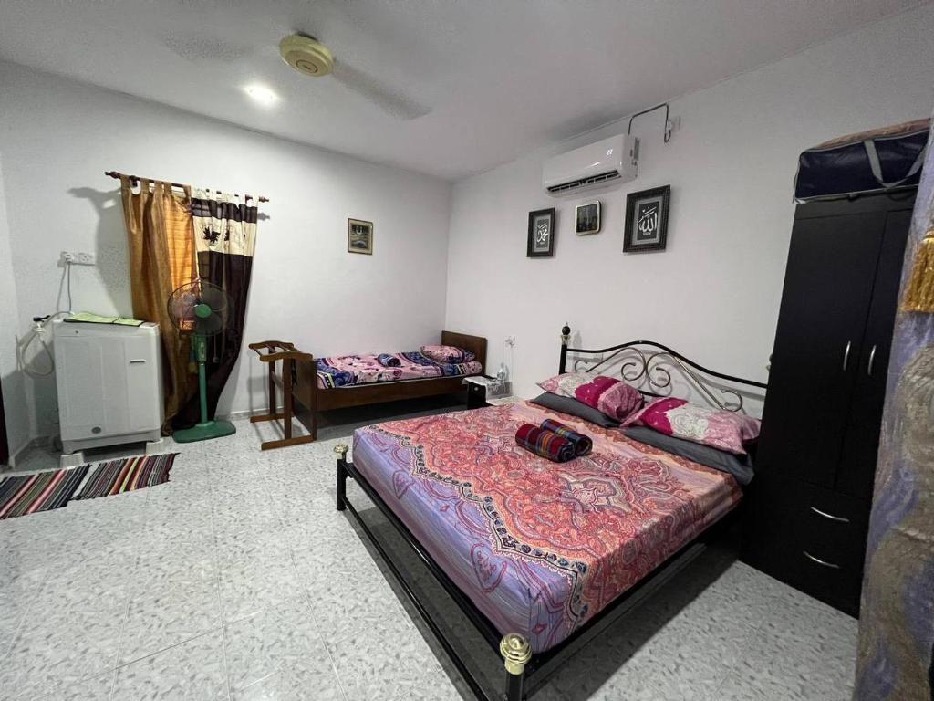 巴力文打Nipah Medium Roomstay Parit Buntar的一间卧室配有一张床、一张沙发和一张四柱床。