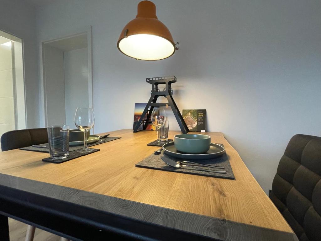 格拉德贝克Zechenbude - Erlebe das Ruhrgebiet的一张木桌,上面放着一盘食物和一盏灯