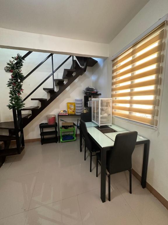 Camaman3 Bedroom Apartment by Romz的一间带桌椅和楼梯的用餐室