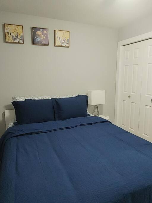 萨斯卡通Oasis of Happiness的卧室配有一张蓝色的床,墙上挂有两张照片
