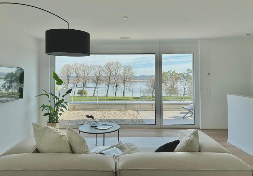 ErmatingenHaus am Bodensee mit Sicht - Stilvoller Luxus的带沙发和大窗户的客厅