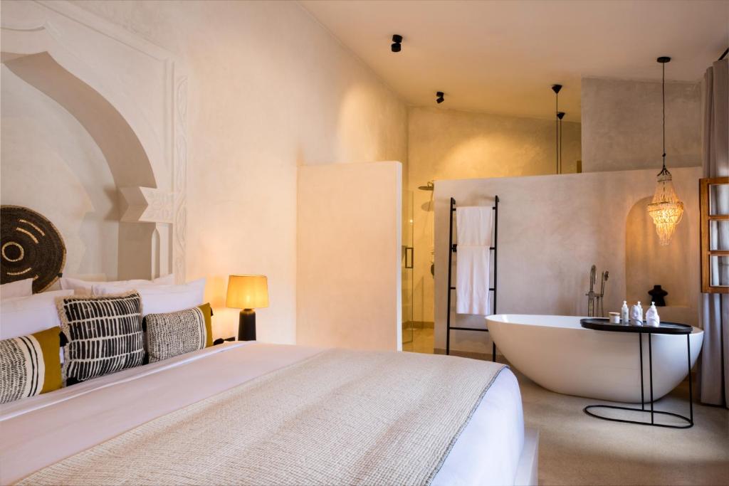 桑给巴尔The Neela Boutique Hotel Stone Town的一间卧室设有一张大床和一个浴缸