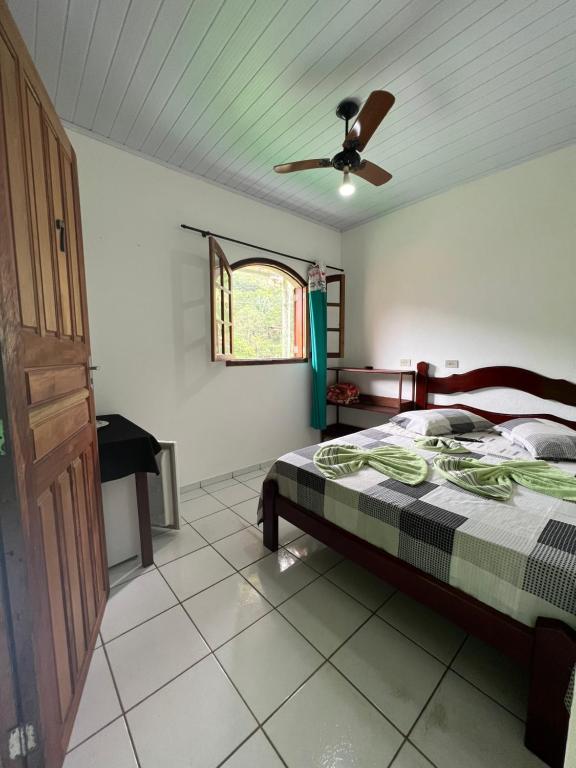 特林达德Pouso da Celeste - Trindade的一间卧室配有一张床和吊扇