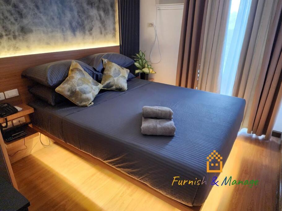 达沃市3 Bedroom Corner Panoramic View的一张大床,上面有蓝色的毯子和枕头