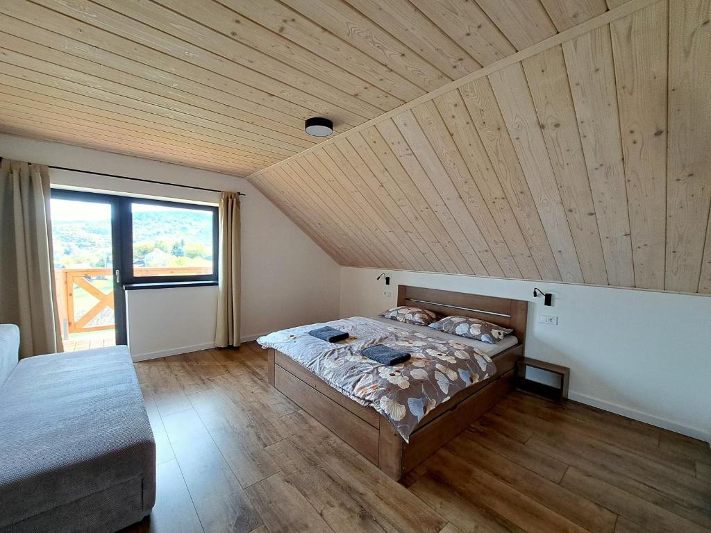RepišteU Hanky pod Hrbkom的一间卧室设有一张床和木制天花板