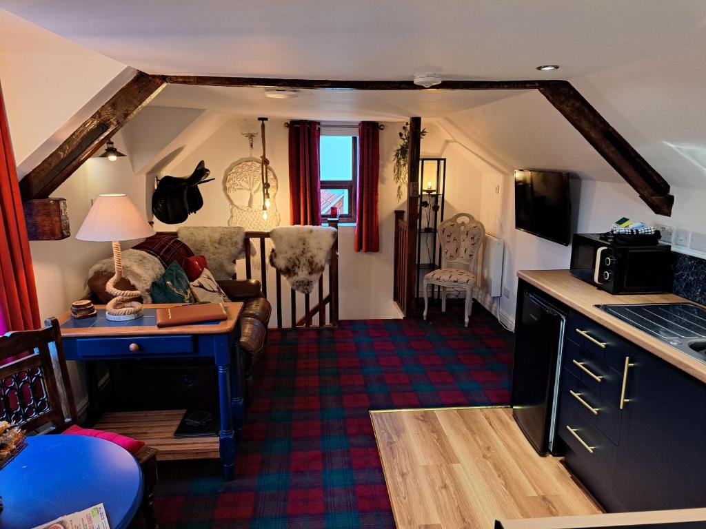 埃德温斯托Willow's Cottage的厨房以及带书桌和沙发的客厅。
